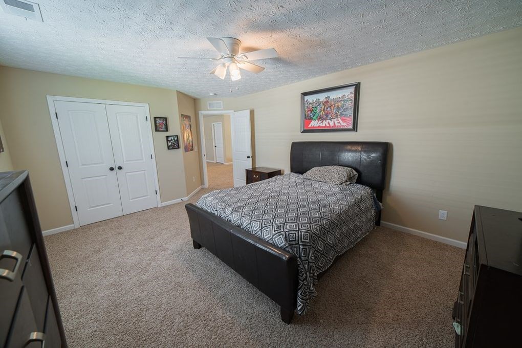 9570 Yarbrough Road Midland, GA 31820 - Photo 19 of 30 a bedroom with a bed and a chandelier
