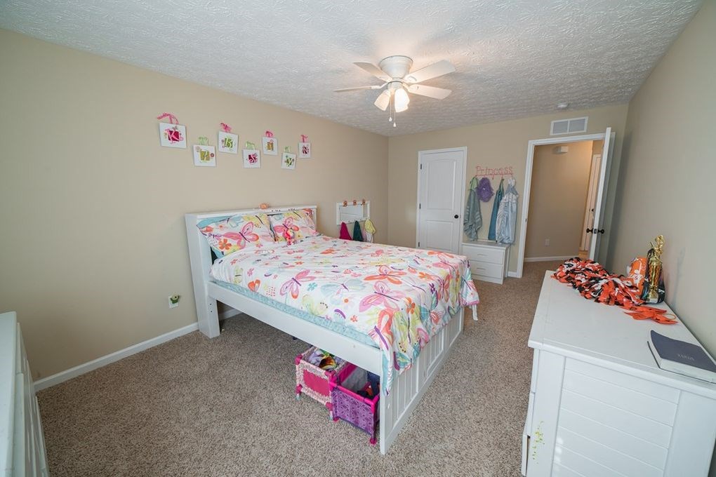 9570 Yarbrough Road Midland, GA 31820 - Photo 20 of 30 a bedroom with a bed and a chandelier