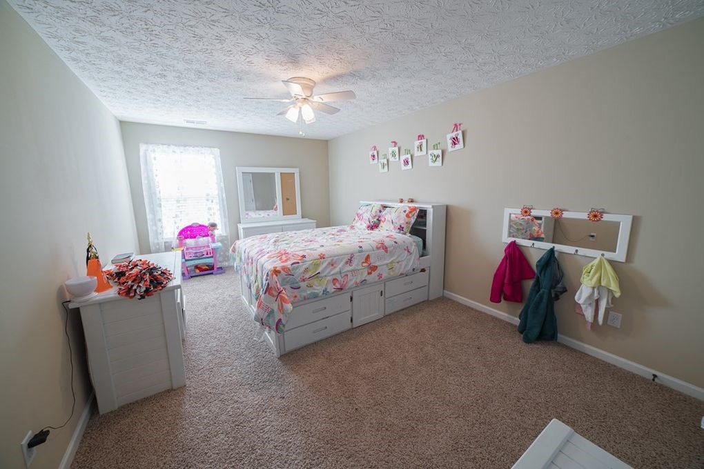 9570 Yarbrough Road Midland, GA 31820 - Photo 21 of 30 a bedroom with bed and a chandelier