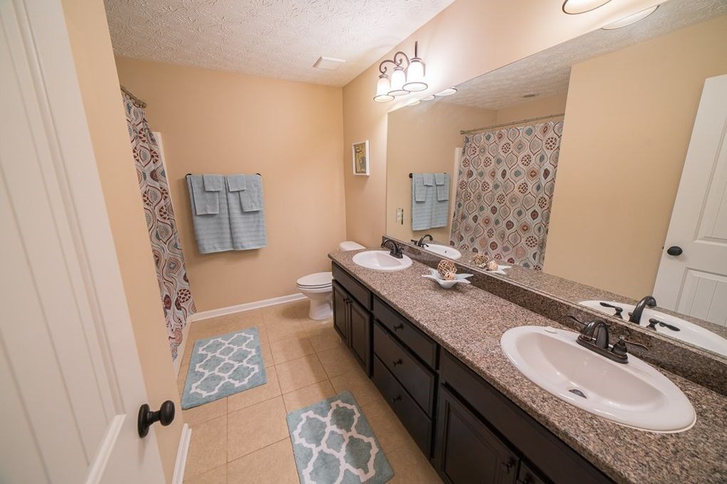 9570 Yarbrough Road Midland, GA 31820 - Photo 22 of 30 a bathroom with double vanity sinks a mirror a vanity and a shower