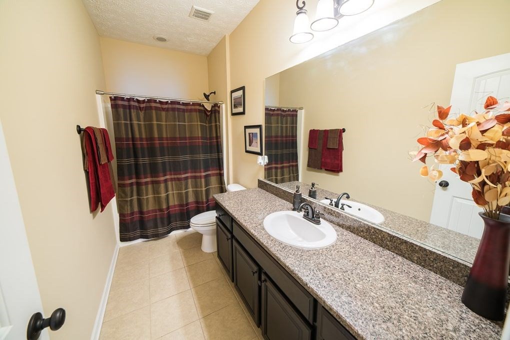 9570 Yarbrough Road Midland, GA 31820 - Photo 24 of 30 a bathroom with a granite countertop sink a toilet and shower