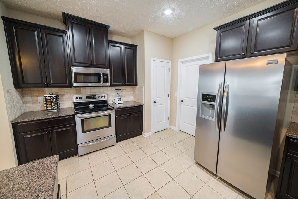 9570 Yarbrough Road Midland, GA 31820 - Photo 6 of 30 a kitchen with granite countertop stainless steel appliances and refrigerator