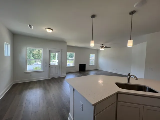 a view of a kitchen with a sink a chandelier and wooden floor
