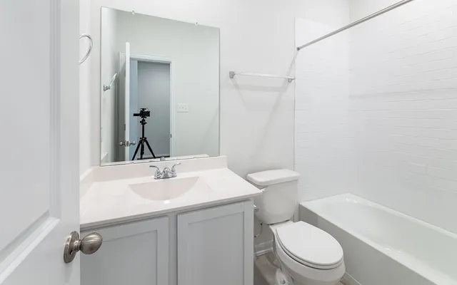 a bathroom with a sink toilet vanity and shower