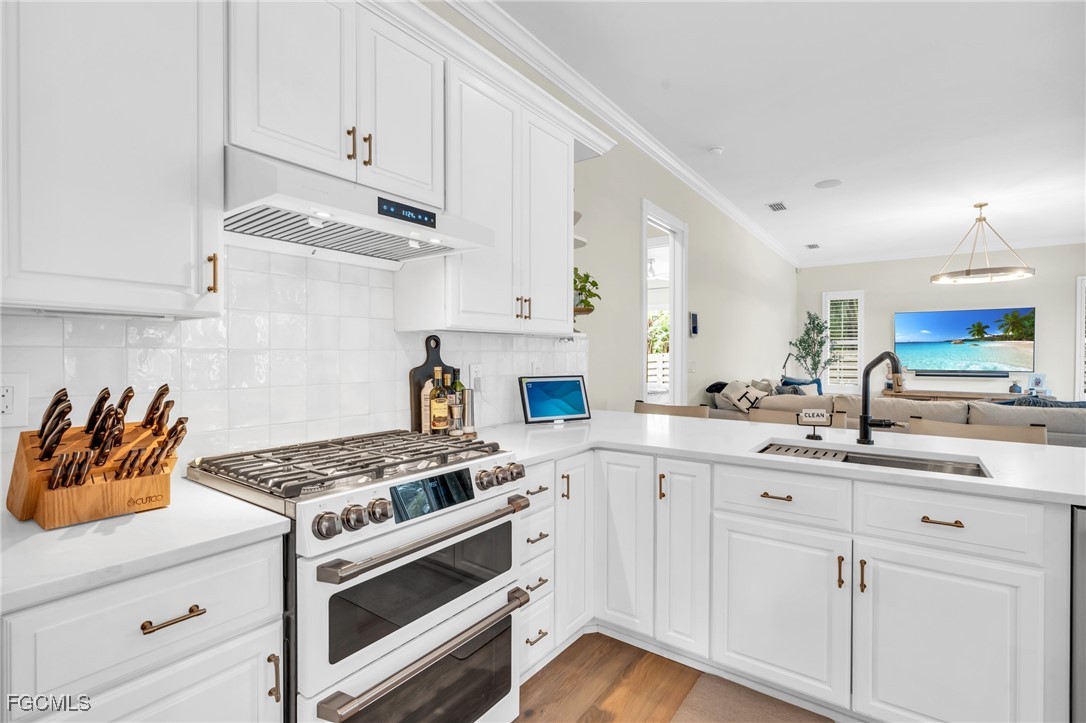 11451 Compass Point Drive Fort Myers, FL 33908 - Photo 13 of 47 a kitchen with white cabinets and appliances