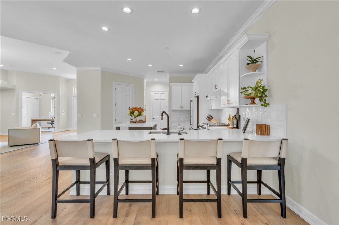 11451 Compass Point Drive Fort Myers, FL 33908 - Photo 16 of 47 a kitchen with a dining table chairs and white cabinets