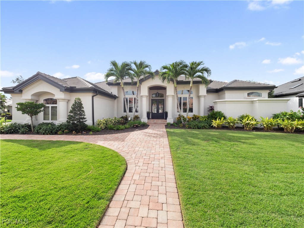 11451 Compass Point Drive Fort Myers, FL 33908 - Photo 2 of 47 a front view of a house with a garden and plants
