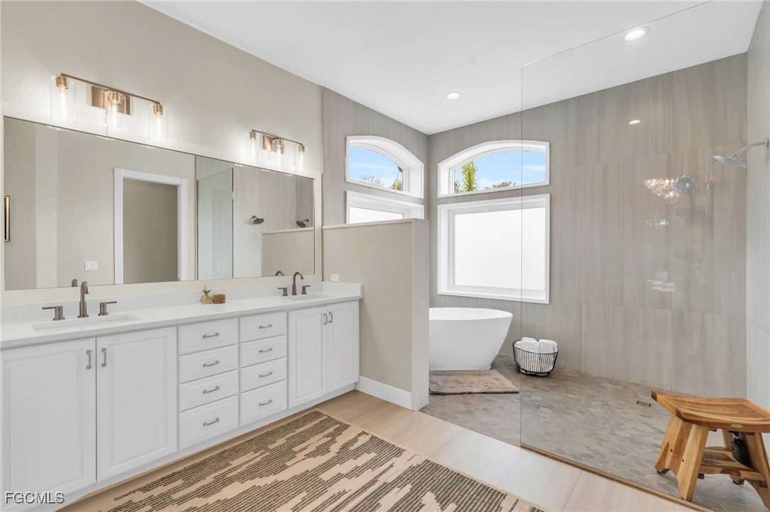 11451 Compass Point Drive Fort Myers, FL 33908 - Photo 23 of 47 a spacious bathroom with double vanity sink a mirror and a shower