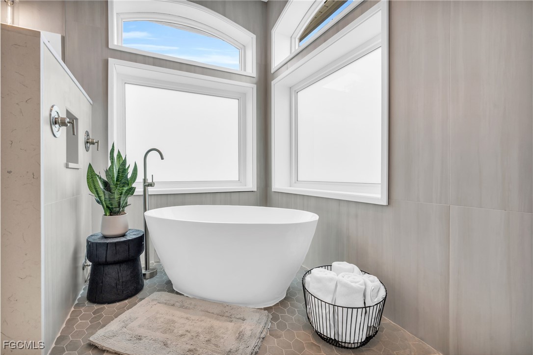 11451 Compass Point Drive Fort Myers, FL 33908 - Photo 24 of 47 a white bath tub sitting in a bathroom next to a window