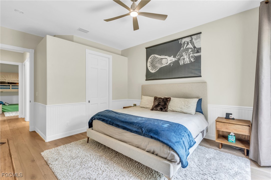 11451 Compass Point Drive Fort Myers, FL 33908 - Photo 32 of 47 a bedroom with a bed and a wooden floor