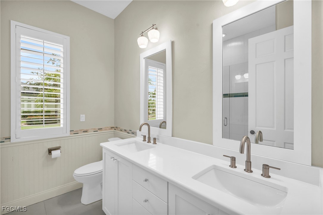 11451 Compass Point Drive Fort Myers, FL 33908 - Photo 35 of 47 a bathroom with a toilet a sink a mirror a window and vanity