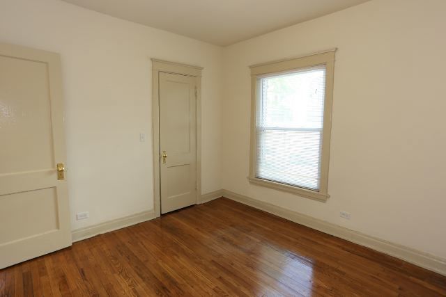 4716 North Racine Avenue, Unit 2E Chicago, IL 60640 - Photo 11 of 19 an empty room with wooden floor and windows