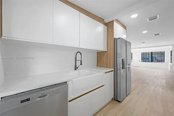 a kitchen with a refrigerator and a sink