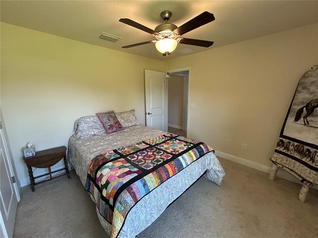 25 Northwest 45th Loop Ocala, FL 34475 - Photo 41 of 61 a bedroom with a bed and a ceiling fan