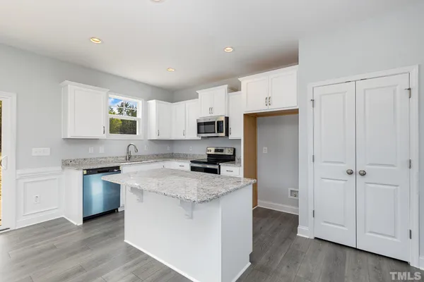 a kitchen with granite countertop white cabinets and stainless steel appliances