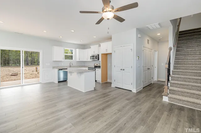 a view of a kitchen with wooden floor and a window