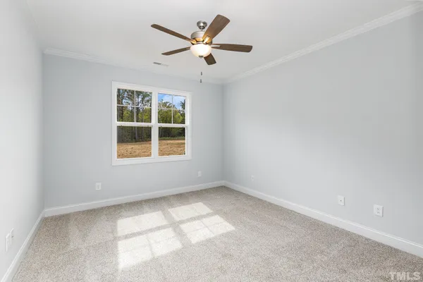an empty room with a window and a ceiling fan