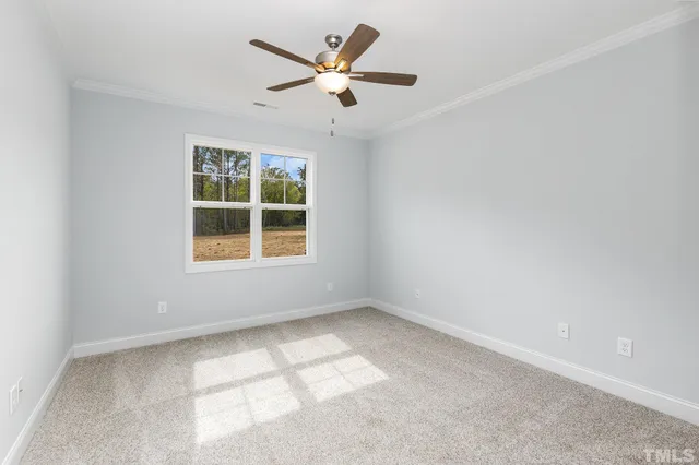 an empty room with a window and a ceiling fan