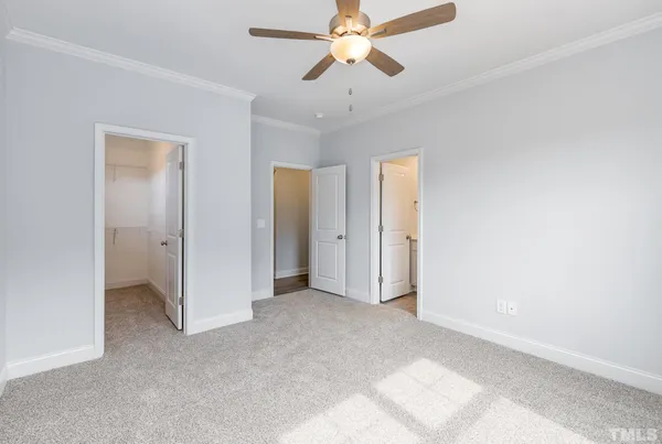 a view of a room with a ceiling fan and closet area