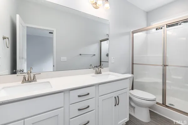 a bathroom with a sink toilet vanity and shower