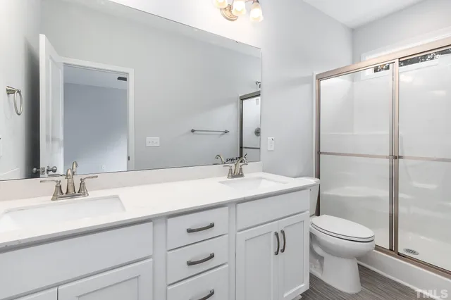 a bathroom with a sink toilet vanity and shower