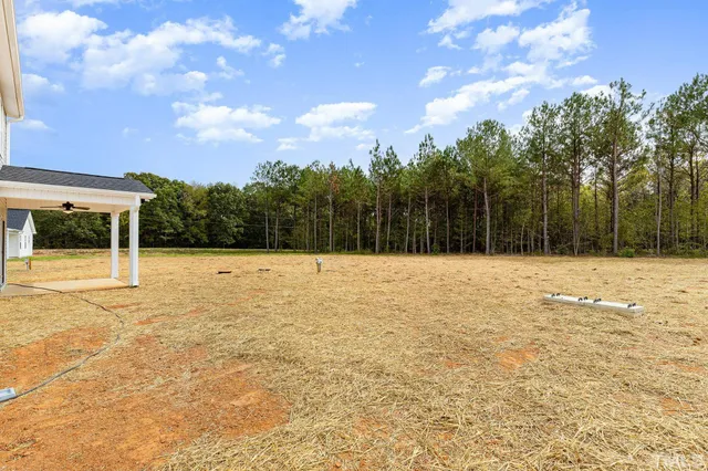 a view of swimming pool with a yard and wooden fence