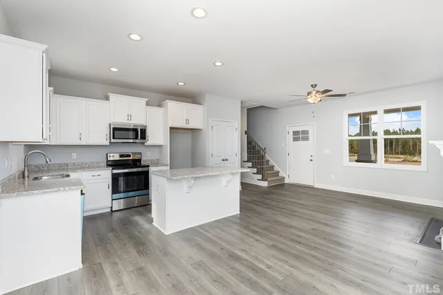 a kitchen with white cabinets and appliances