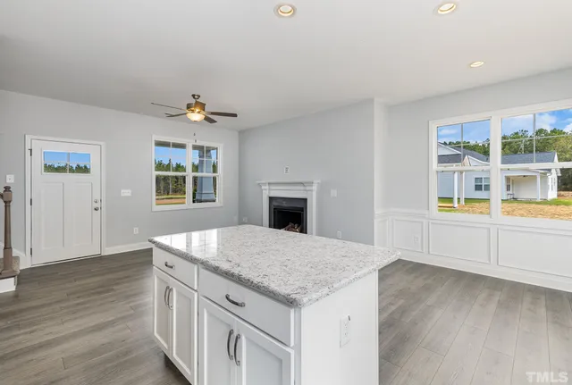 a kitchen with granite countertop a stove and a wooden floors