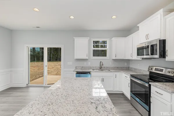 a kitchen with stainless steel appliances granite countertop a stove a sink and a microwave