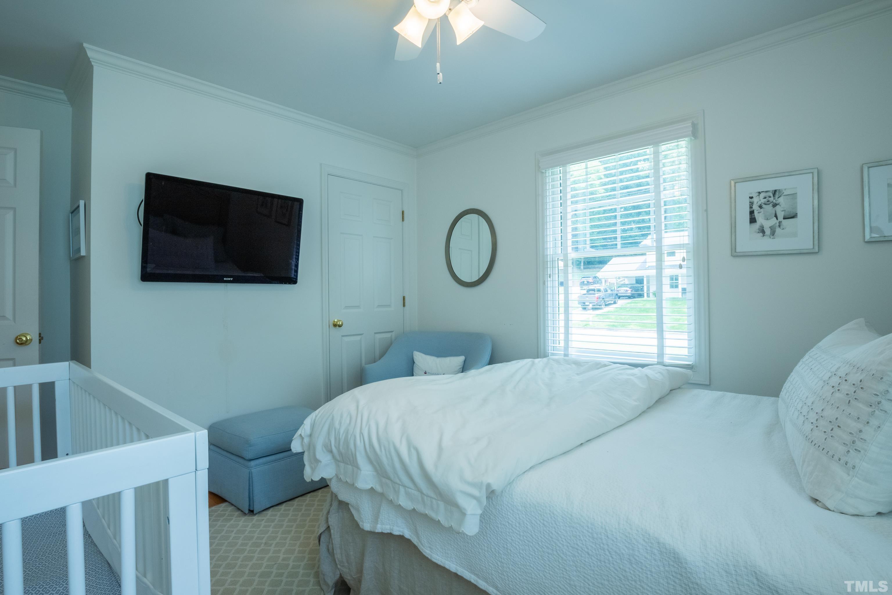 816 Davidson Street Raleigh, NC 27609 - Photo 25 of 36 a bedroom with a bed a flat screen tv and a window