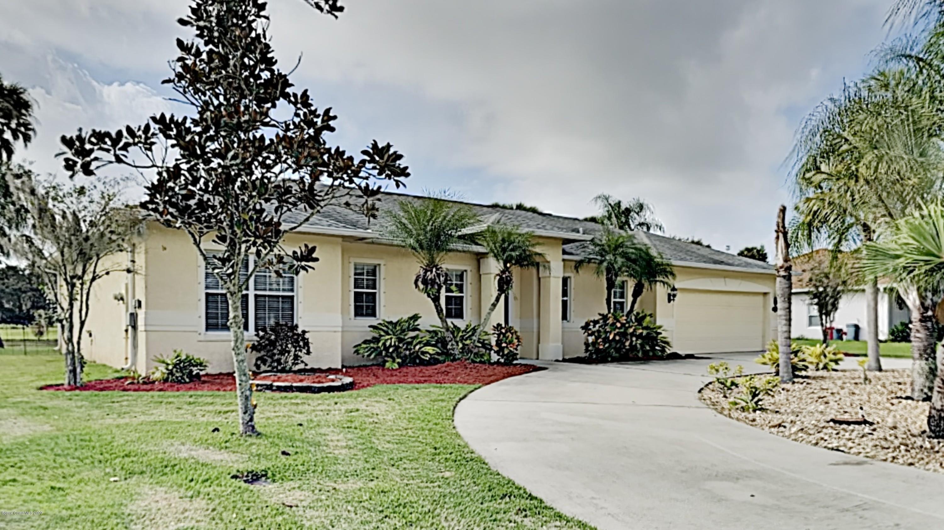 830 Riviera Drive Northeast Palm Bay, FL 32905 - Photo 1 of 21 a front view of a house with garden