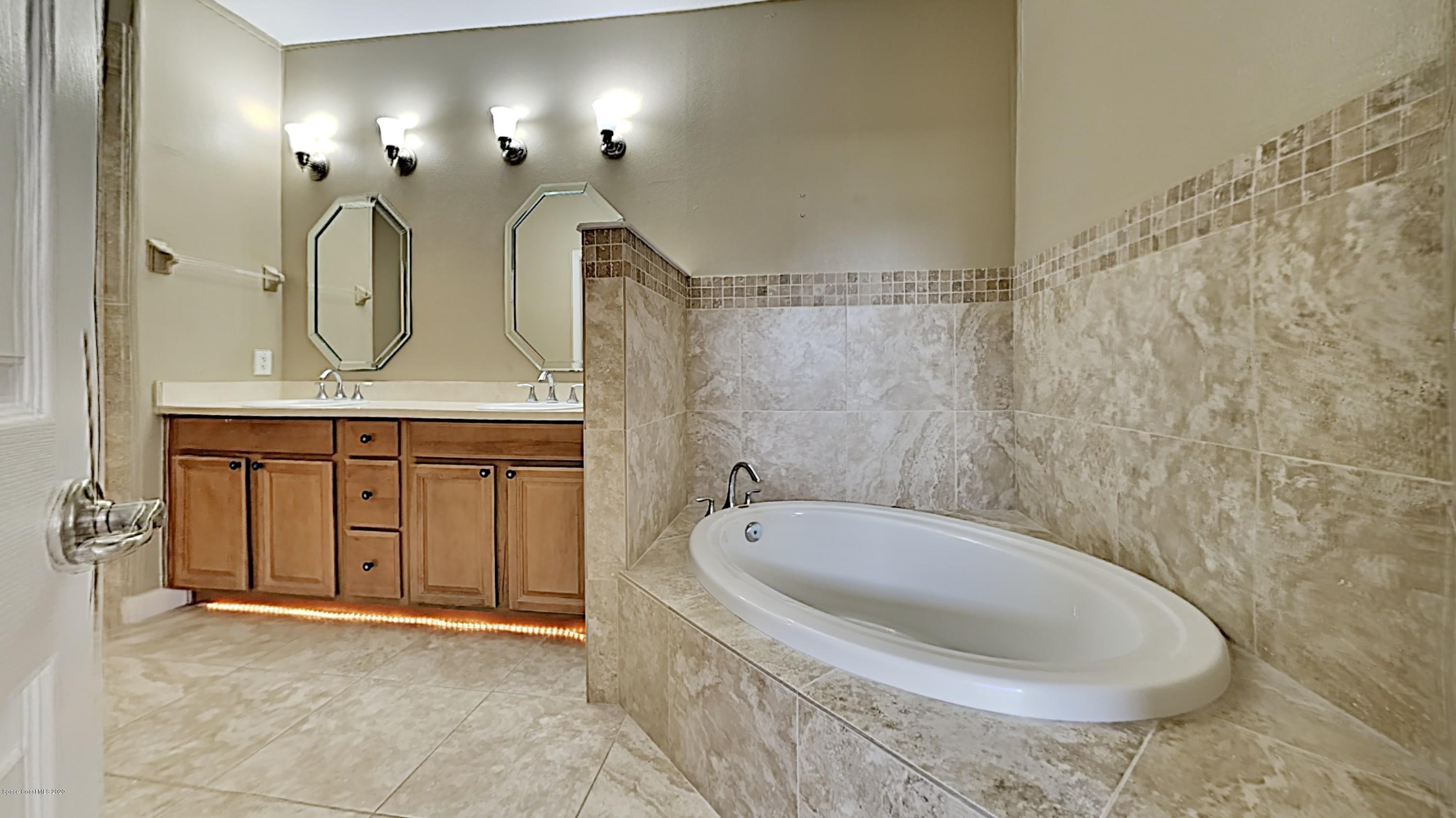 830 Riviera Drive Northeast Palm Bay, FL 32905 - Photo 11 of 21 a spacious bathroom with a double vanity sink and a mirror