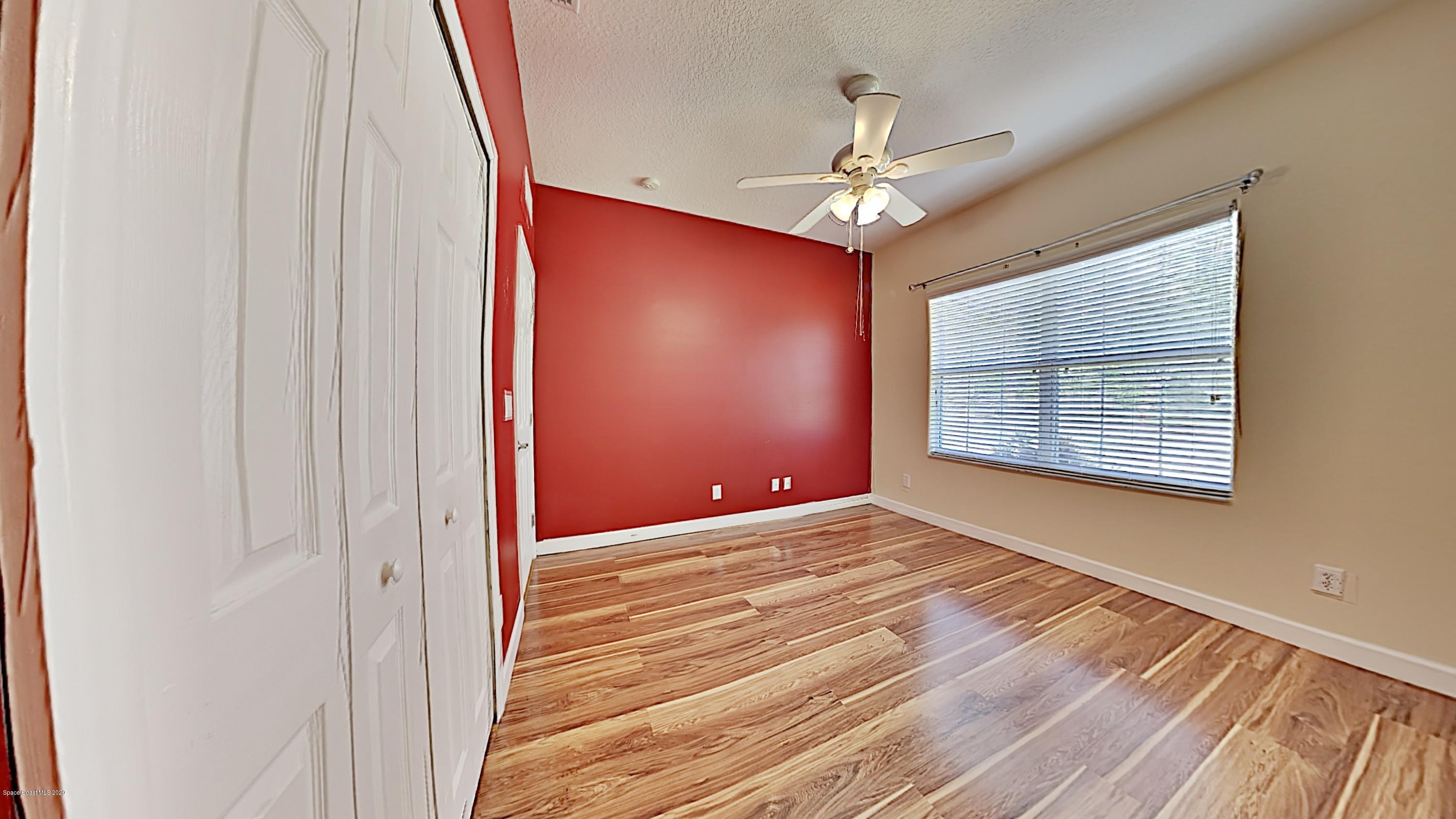830 Riviera Drive Northeast Palm Bay, FL 32905 - Photo 14 of 21 a view of an empty room with wooden floor and a window