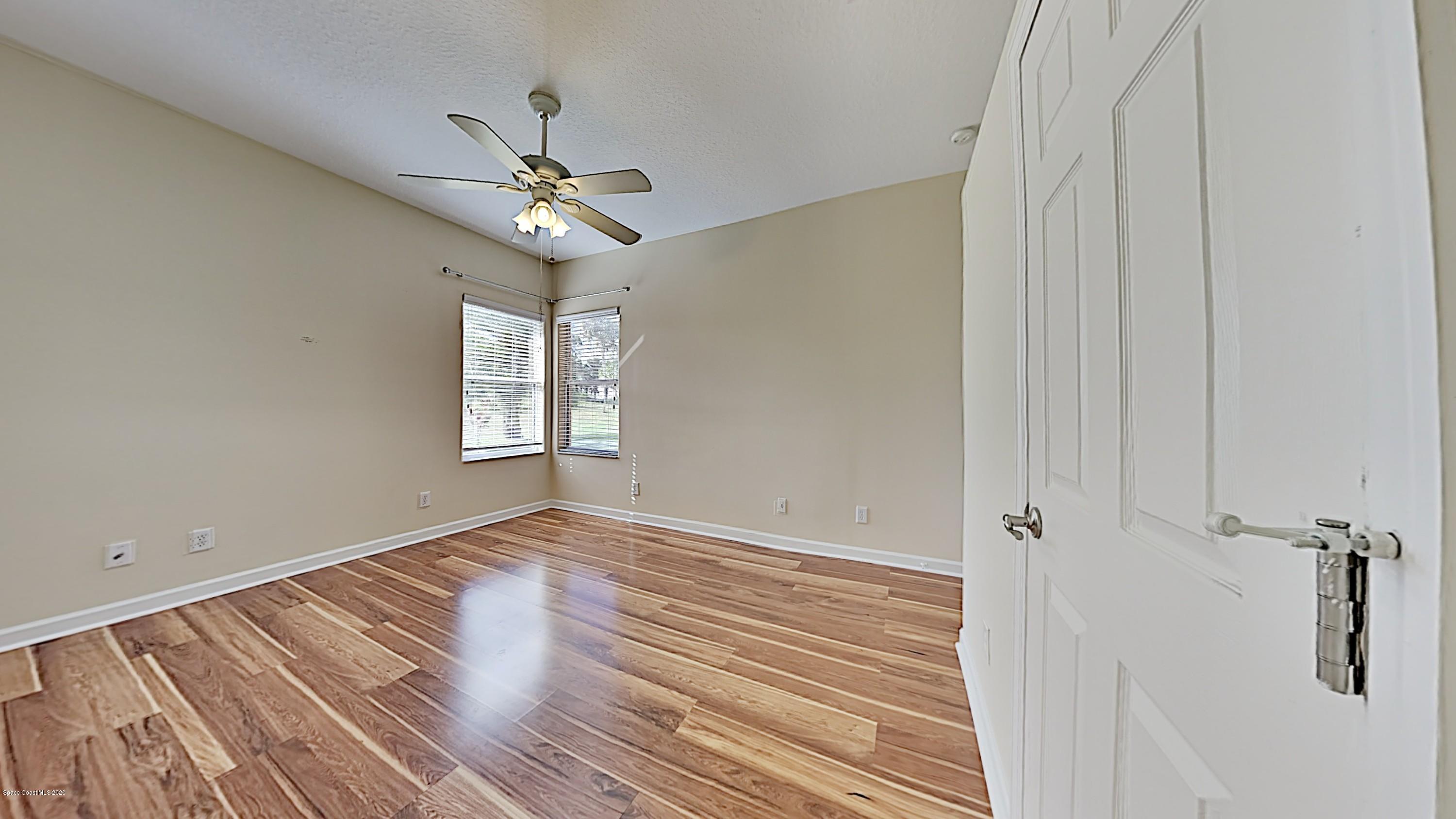 830 Riviera Drive Northeast Palm Bay, FL 32905 - Photo 16 of 21 wooden floor in an empty room with a window