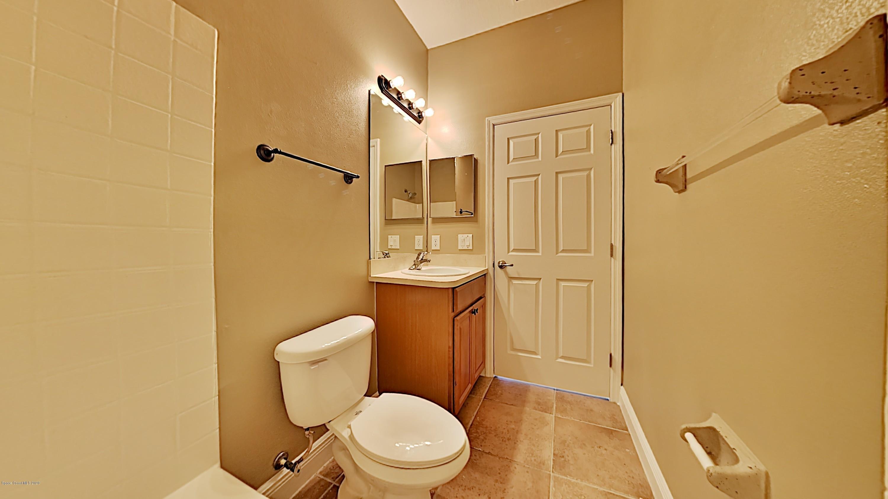 830 Riviera Drive Northeast Palm Bay, FL 32905 - Photo 17 of 21 a white toilet sitting next to a bathroom sink