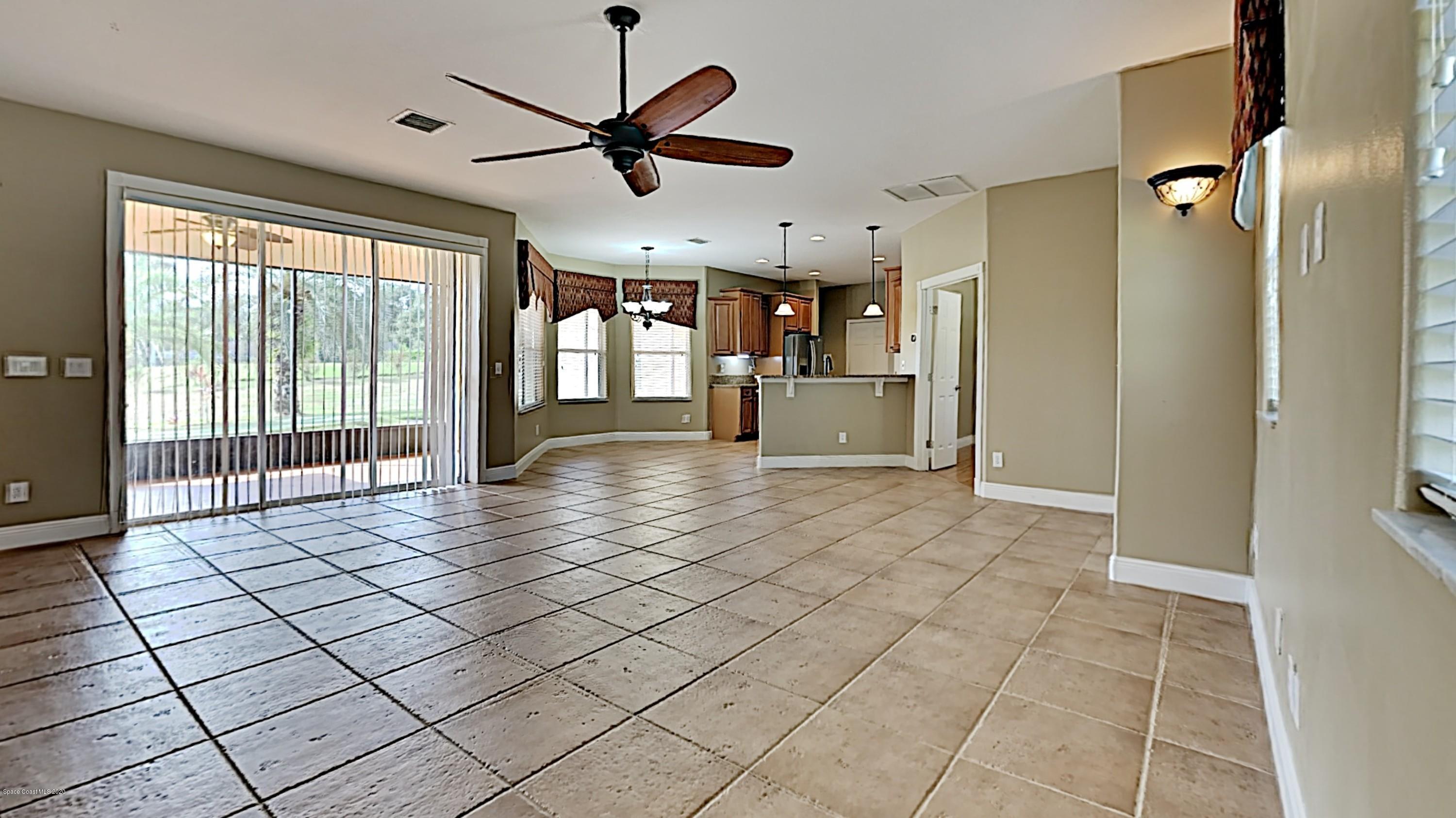 830 Riviera Drive Northeast Palm Bay, FL 32905 - Photo 3 of 21 a view of empty room with wooden floor and fan