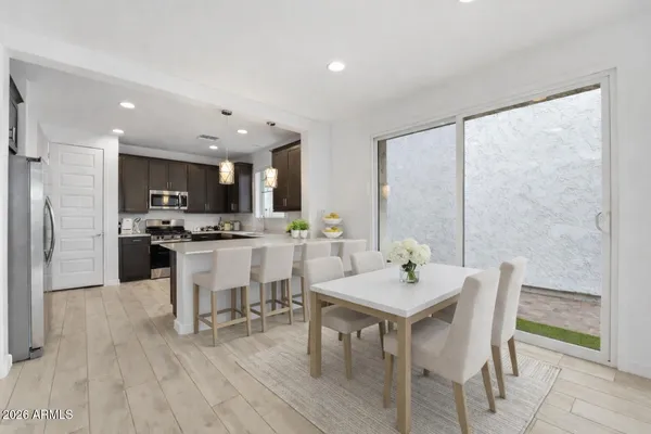 a kitchen with stainless steel appliances granite countertop a sink a stove a refrigerator cabinets and a window