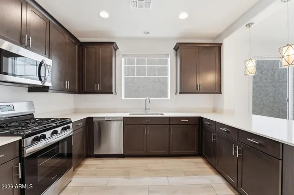 a kitchen with stainless steel appliances granite countertop a refrigerator and a sink