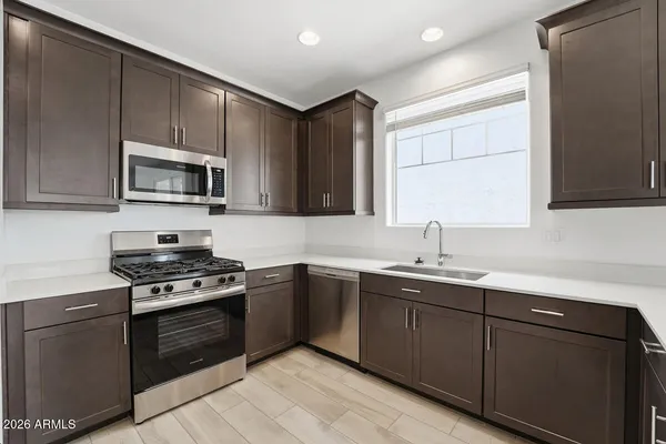 a kitchen with stainless steel appliances a sink and a refrigerator
