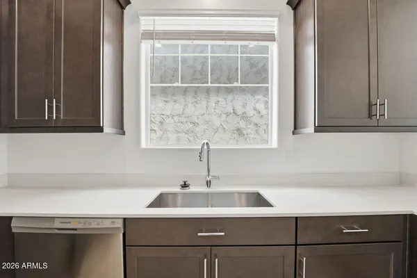 a large kitchen with a large counter top stainless steel appliances and cabinets