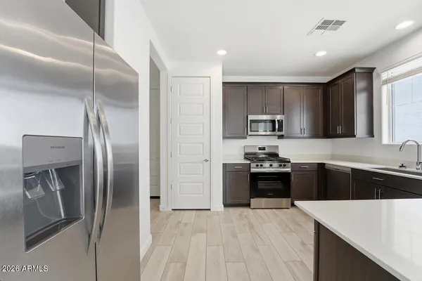 a kitchen with granite countertop a refrigerator and a sink