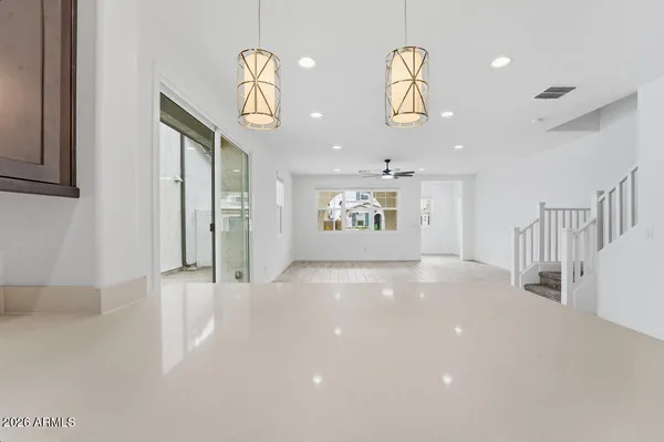 an empty room with windows and ceiling fan
