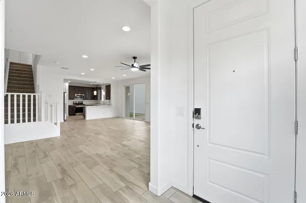 wooden floor in an empty room with a window and a kitchen