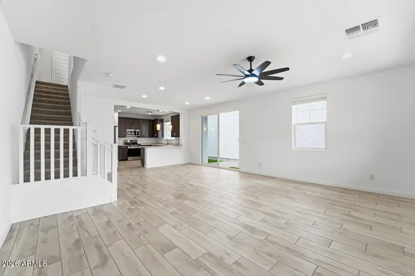 a view of an empty room with window and wooden floor
