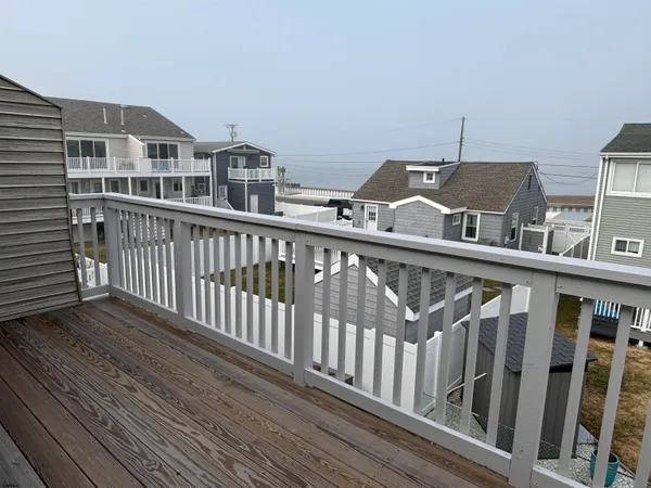 a view of a balcony with wooden floor and fence
