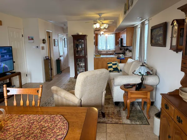 a living room with furniture kitchen view and a window