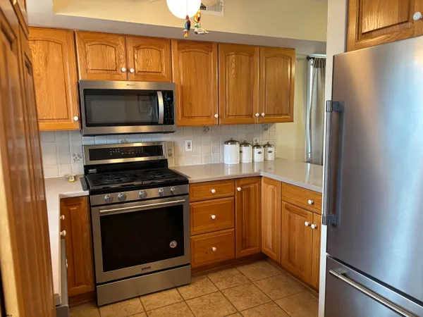 a kitchen with stainless steel appliances granite countertop a refrigerator stove and sink
