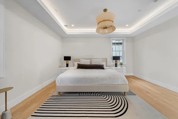 a bedroom with a bed and wooden floor