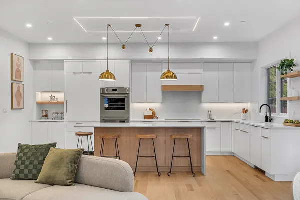 a living room with kitchen furniture and a wooden floor