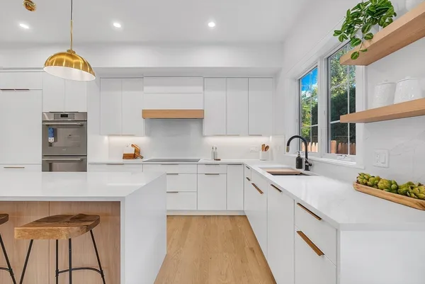 a kitchen with stainless steel appliances granite countertop a sink a stove and a refrigerator